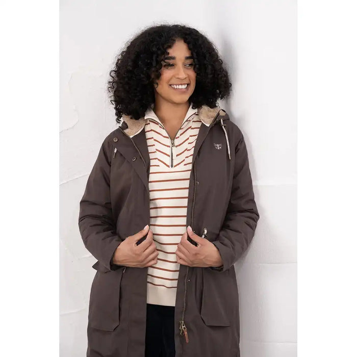 Person wearing a brown coat over a striped shirt against a white background