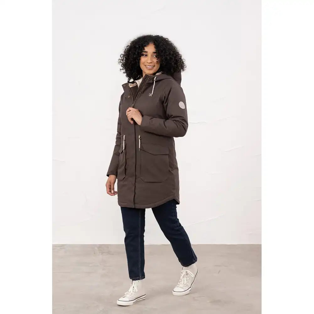 Woman wearing a long brown coat with a white background