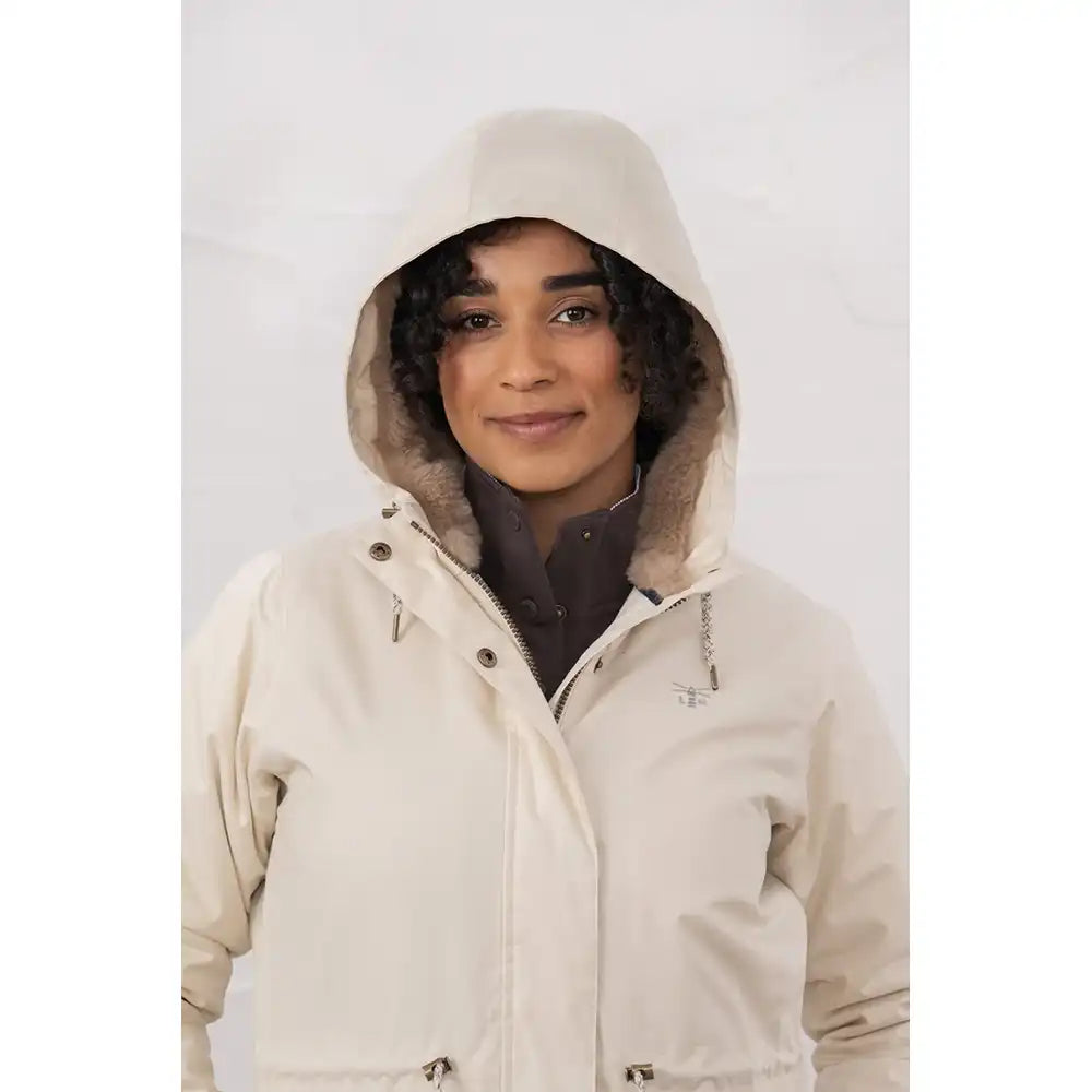 Person wearing a beige hooded jacket with fur lining on a white background