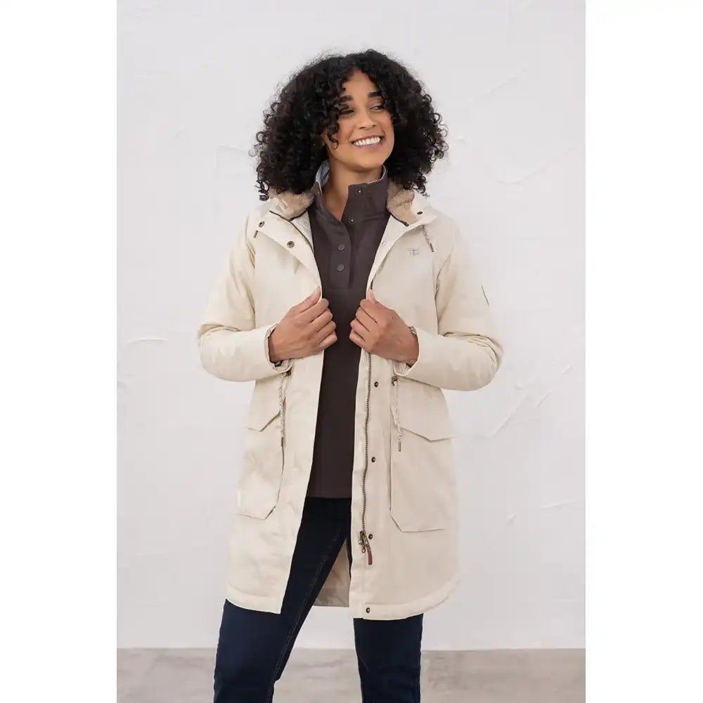 Woman wearing a beige parka against a white background