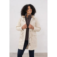Woman wearing a beige parka against a white background