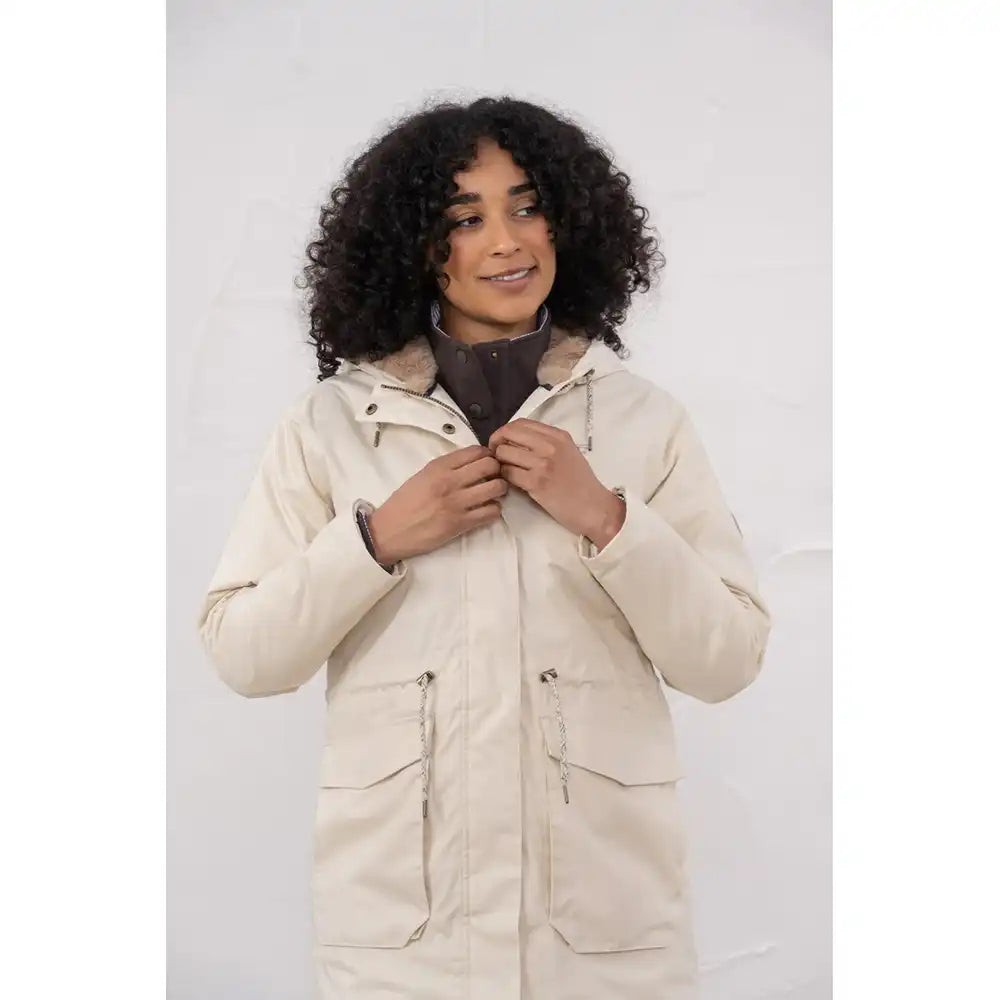 Woman wearing a beige parka against a white background