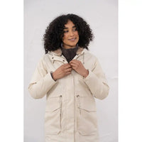 Woman wearing a beige parka against a white background