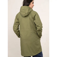A woman shown from the back wearing a mid-length olive green hooded puffer jacket against a light off-white background.