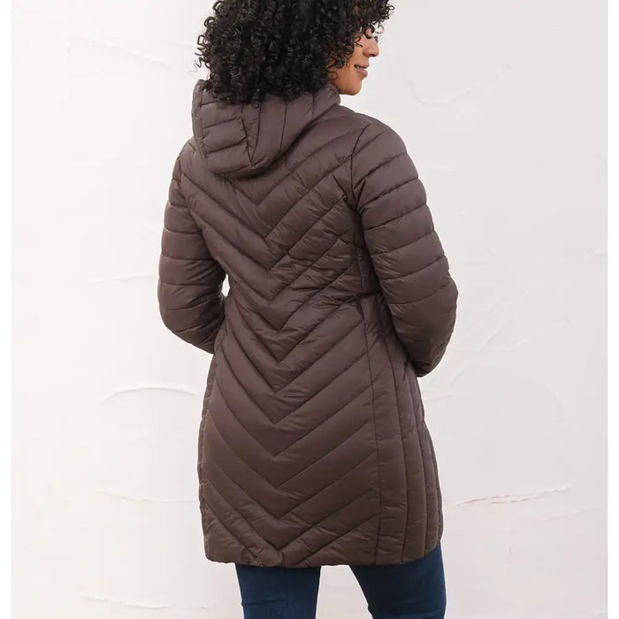 A woman shown from the back wearing a dark brown chevron-quilted hooded puffer coat, paired with dark blue jeans, against a white textured wall.