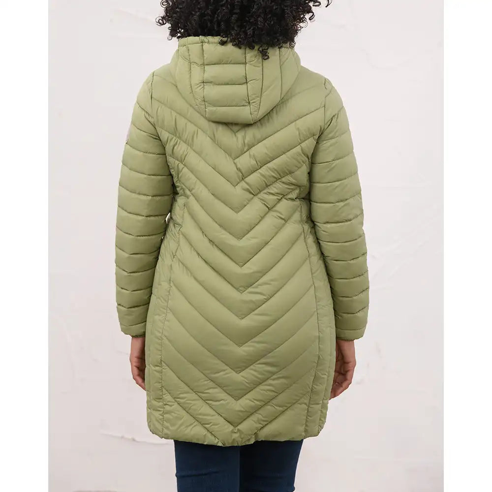 A person shown from the back wearing a hooded quilted puffer coat in an olive green color, paired with dark blue jeans, against a plain off-white wall.
