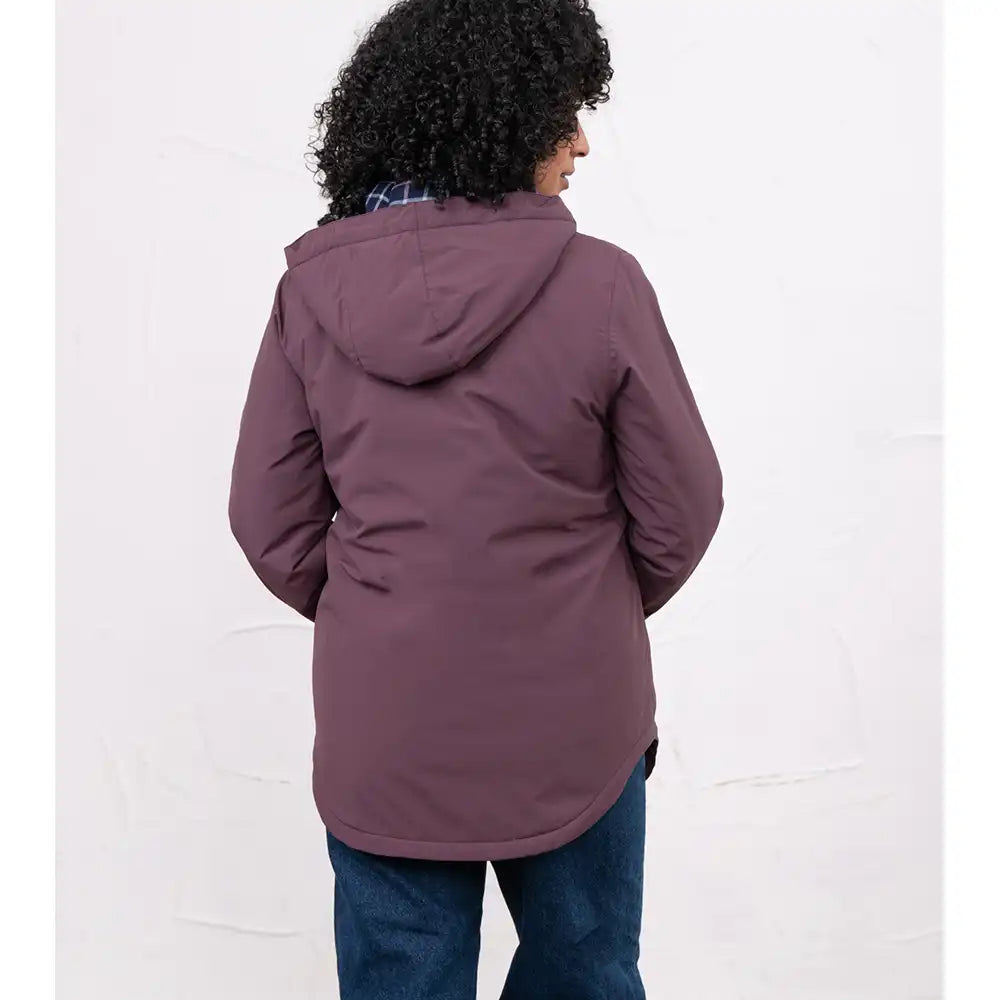 A person shown from the back wearing a muted plum-purple hooded jacket and blue jeans against a plain white studio background.