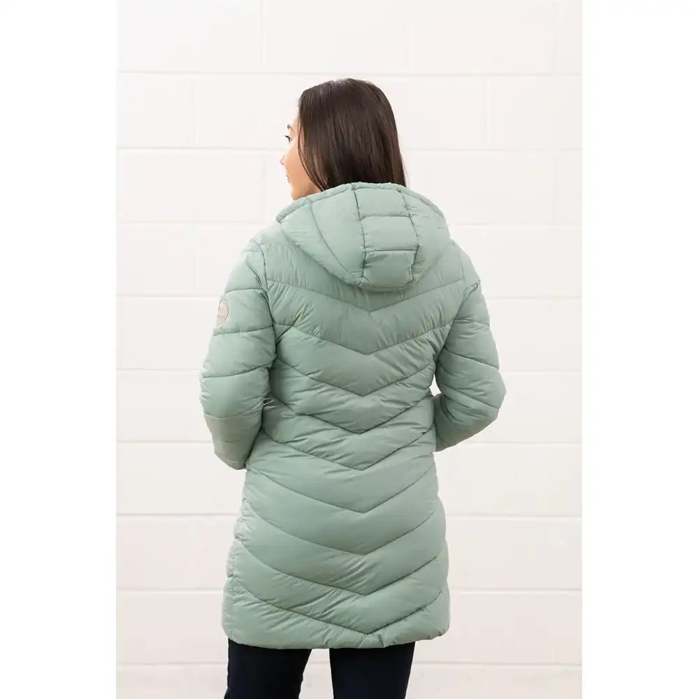 Person wearing a light green quilted jacket against a white background
