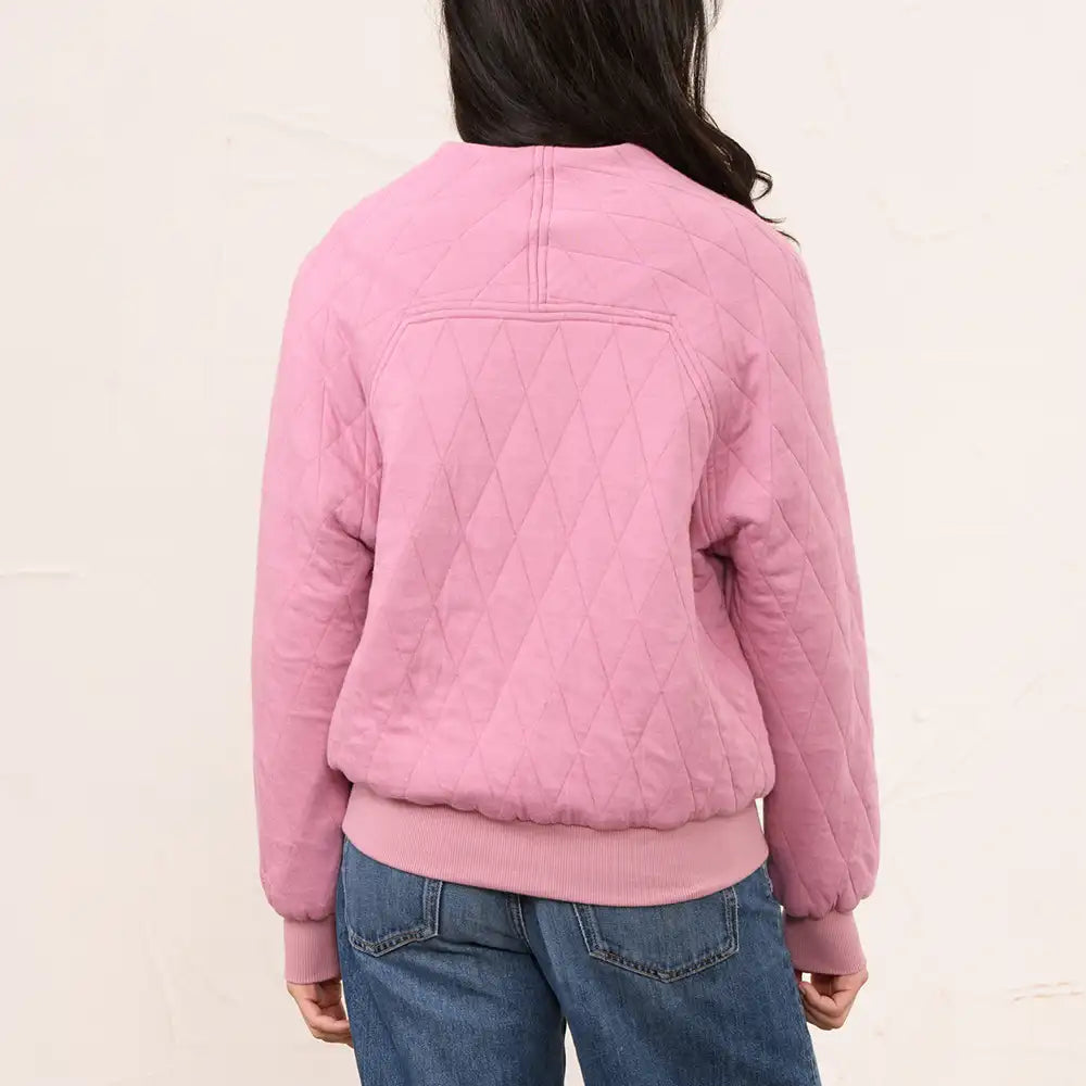 A person shown from the back wearing a pink quilted bomber-style jacket with a diamond-quilted pattern, ribbed collar, cuffs, and hem, paired with blue jeans against a plain off-white background.