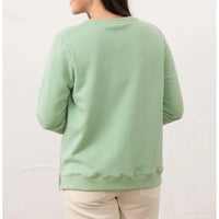 Person wearing a light green sweatshirt on a white background