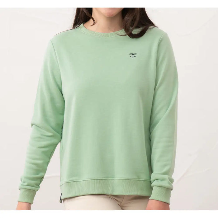 Person wearing a light green sweatshirt with a small logo on a white background