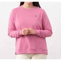 Person wearing a pink sweatshirt with a small logo on a white background