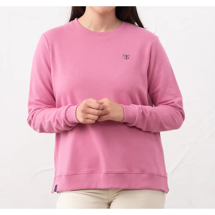Person wearing a pink sweatshirt with a small logo on a white background