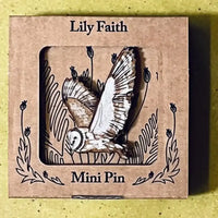 A wooden barn owl mini pin with spread wings displayed inside a square kraft paper window box labeled 'Lily Faith' and 'Mini Pin'.