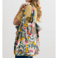 Floral-patterned bag over a person's shoulder on a white background