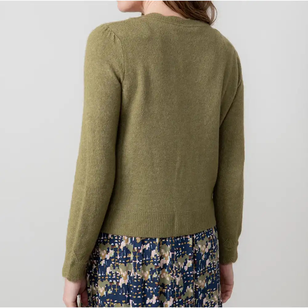 Person wearing a green sweater with a plain background