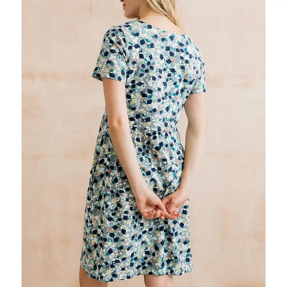 Woman wearing a floral dress against a beige background
