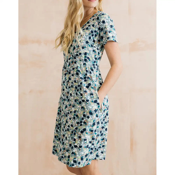 Woman wearing a floral dress against a wooden background