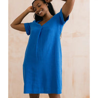 Woman wearing a blue dress against a beige background