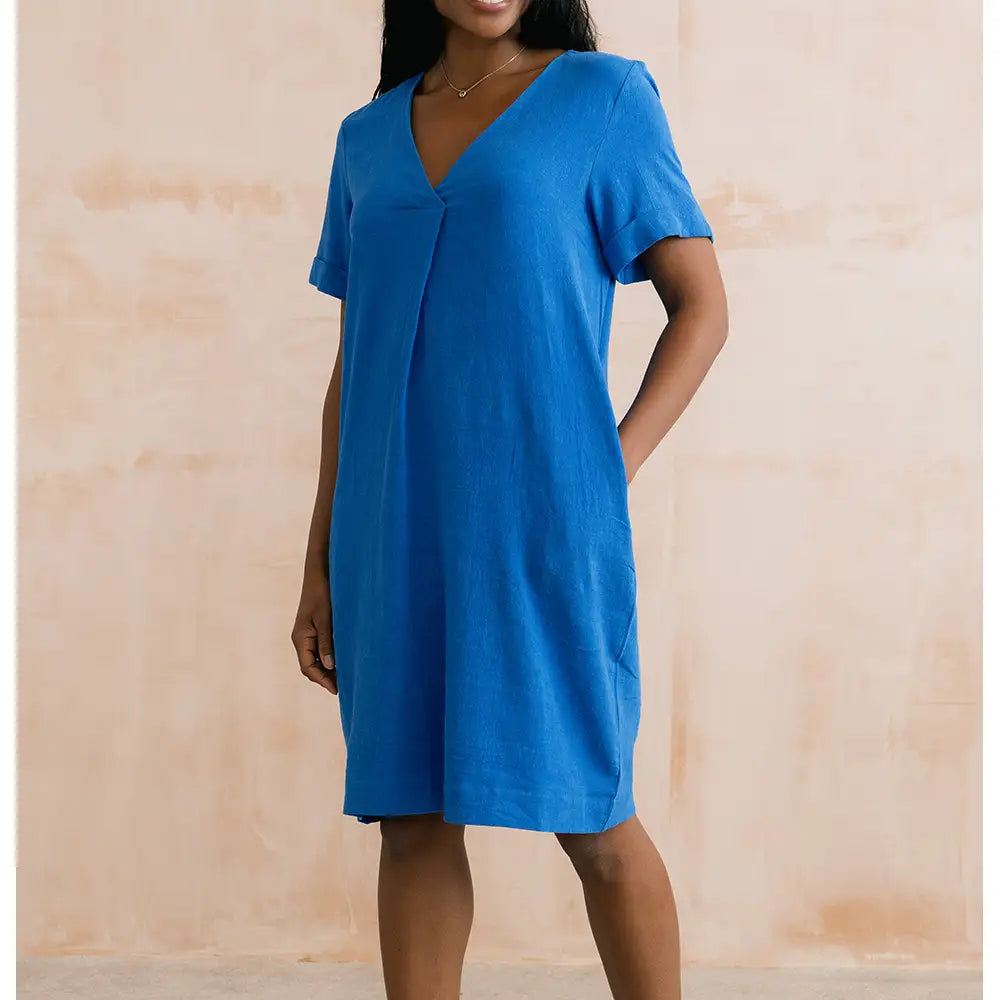 Woman wearing a blue dress against a beige background