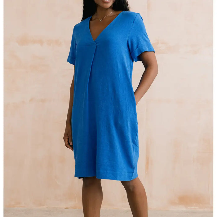 Woman wearing a blue dress against a beige background