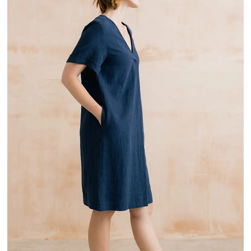 Woman wearing a blue dress against a wooden background