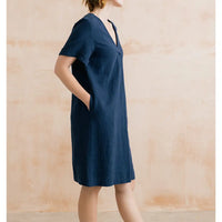 Woman wearing a blue dress against a wooden background