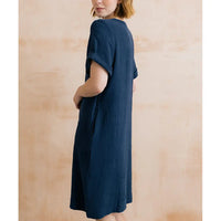 Woman wearing a blue dress against a wooden background