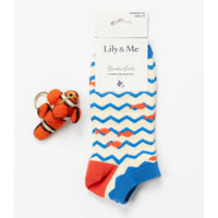 Pair of socks with fish pattern and keychain on a white background