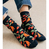 Navy socks with fox and berry pattern worn by a person on a light background