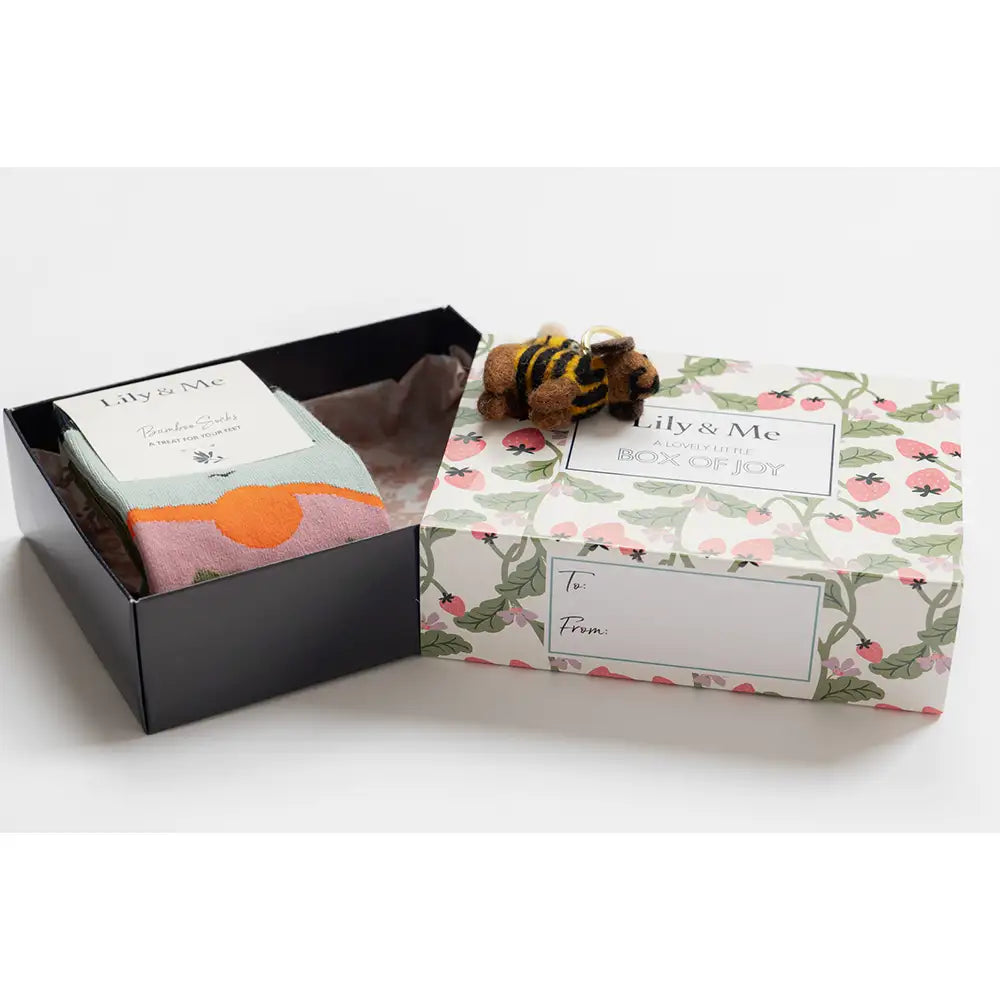 Gift box with floral design and a small toy on a white background
