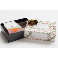 Gift box with floral design and a small toy on a white background