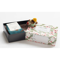 Gift set with teddy bear, photo album, and card in a decorative box on a white background