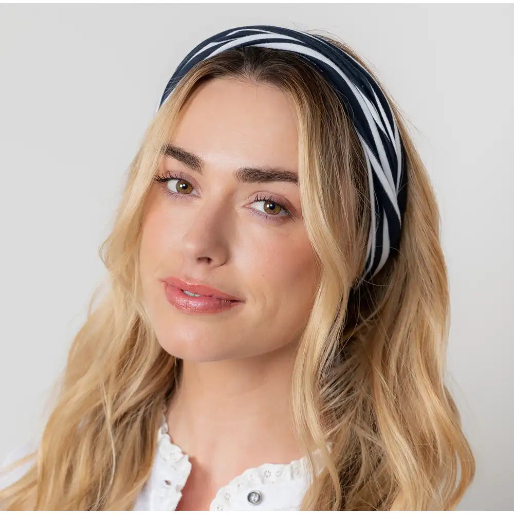 Woman wearing a striped headband against a plain background