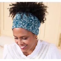 Woman wearing a blue patterned headband against a beige background