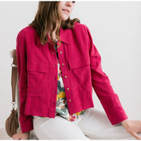 Person wearing a bright pink jacket with a neutral background