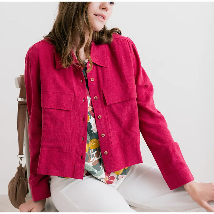 Person wearing a bright pink jacket with a neutral background