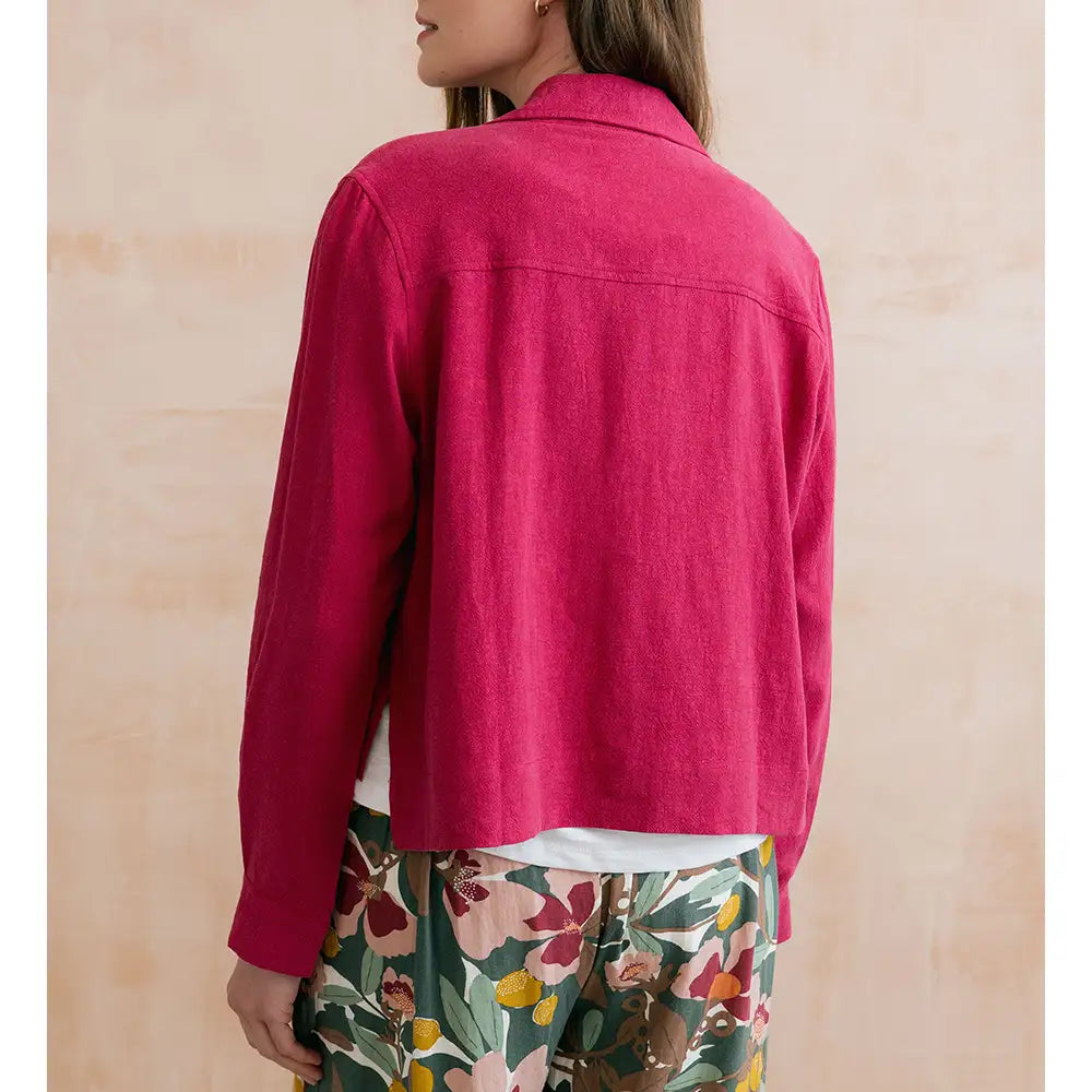 Person wearing a bright pink jacket with a neutral background