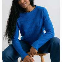 Front of a cobalt blue jumper with scalloped round neck and cuffs on long sleeves. Horizontal pointelle detailing across the body and arms.