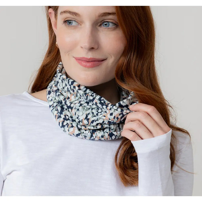 Woman wearing a patterned scarf against a plain background