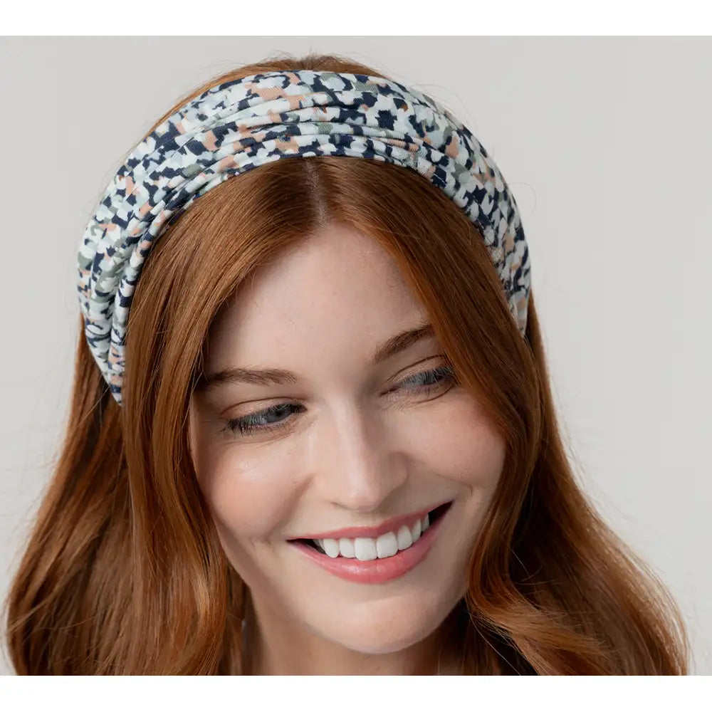 Woman wearing a patterned headband against a plain background