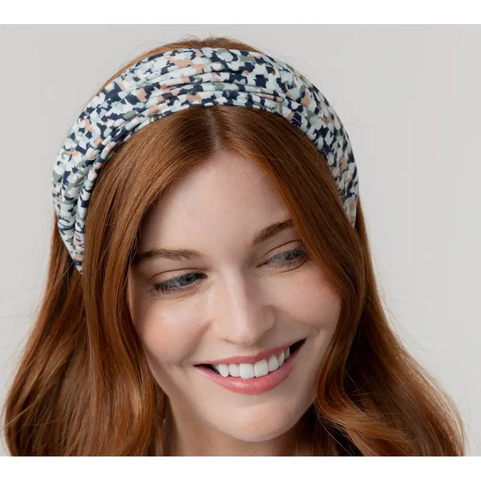Woman wearing a patterned headband against a plain background