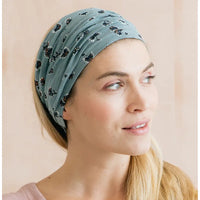 Woman wearing a blue patterned headband against a beige background