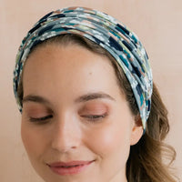 Woman wearing a patterned headband against a beige background