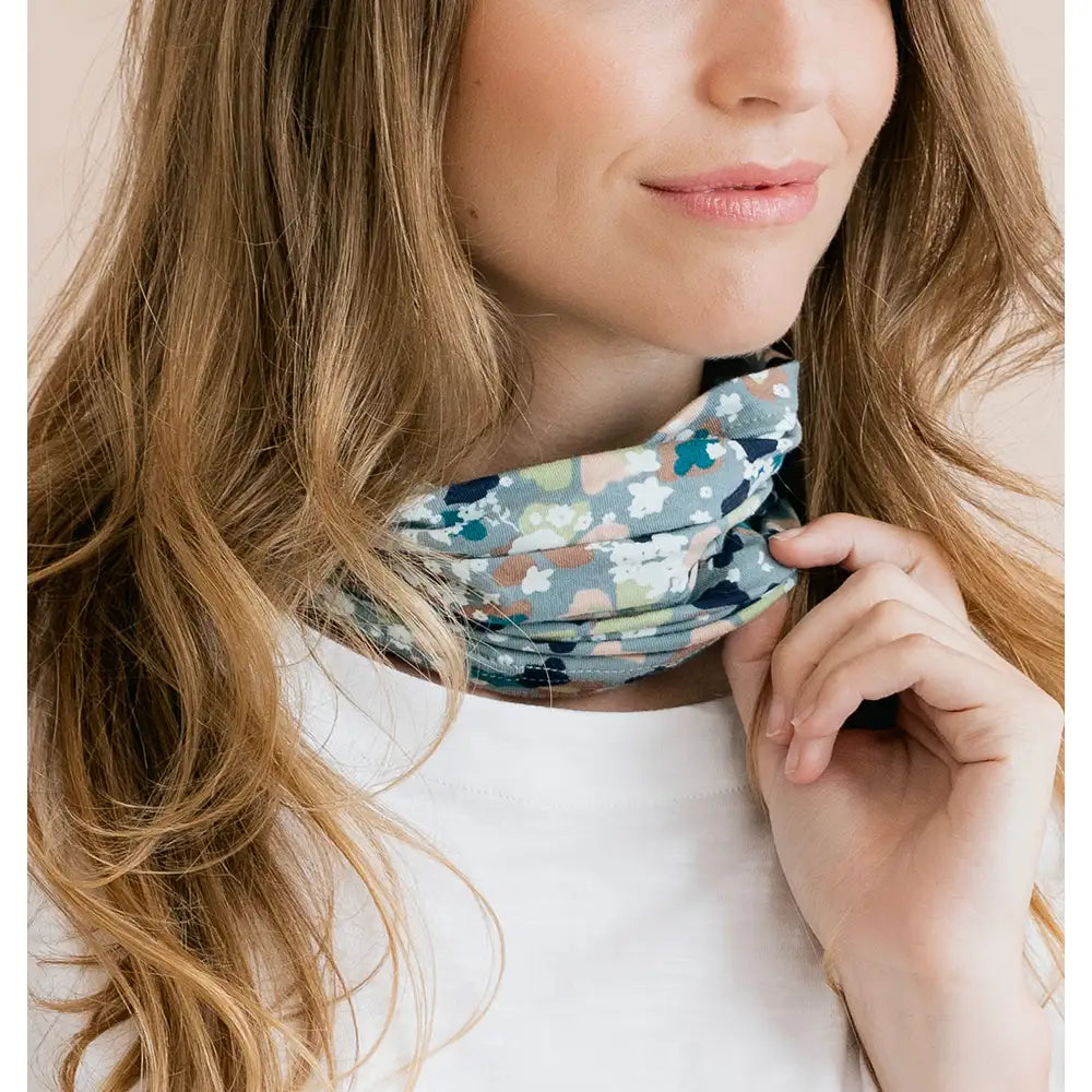 Woman wearing a colorful patterned scarf around her neck with a plain background