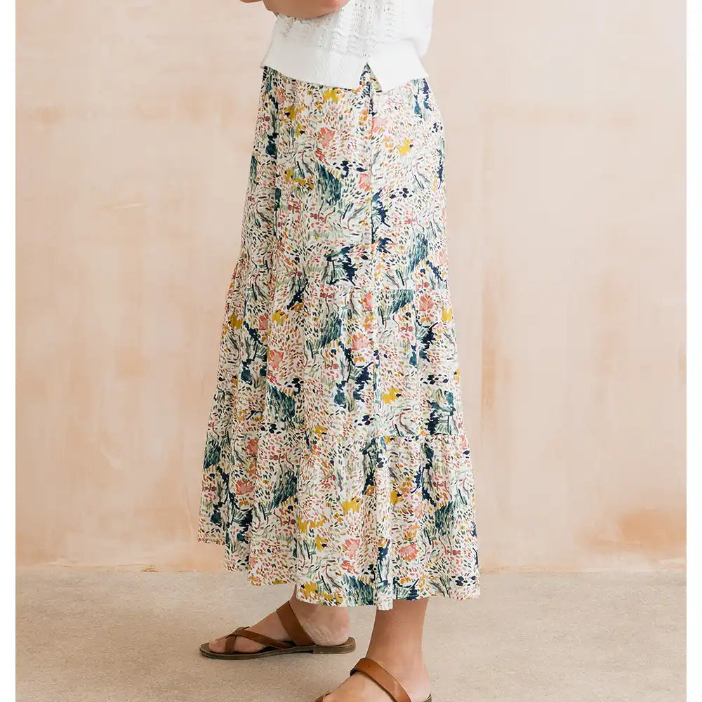 Person wearing a floral skirt with a neutral background