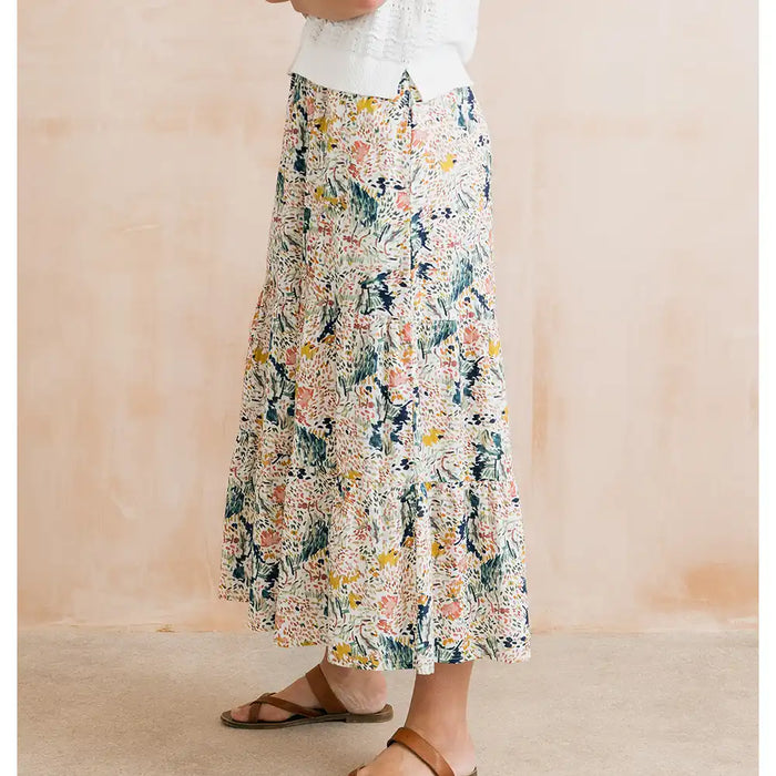Person wearing a floral skirt with a neutral background