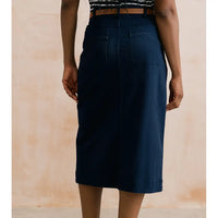Navy blue skirt worn by a person on a beige background