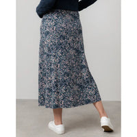 Person wearing a floral skirt with a neutral background