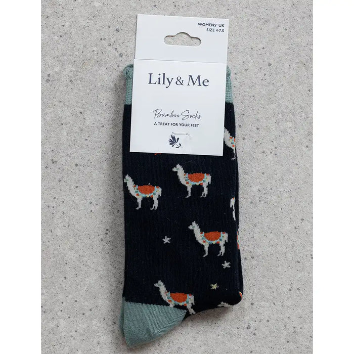 Packaged socks with llama design on a gray surface, featuring 'Lily & Me' branding.